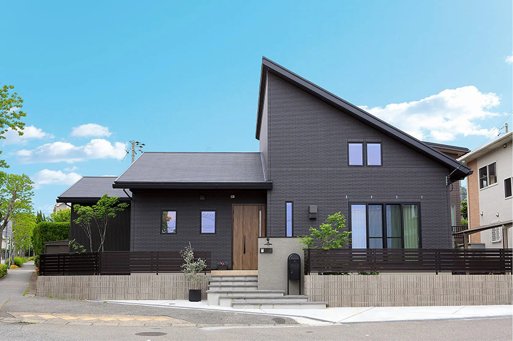 木目調のキッチンで夫婦が料理の準備をしており、猫がカウンター上に座っている温かな日常の一コマ