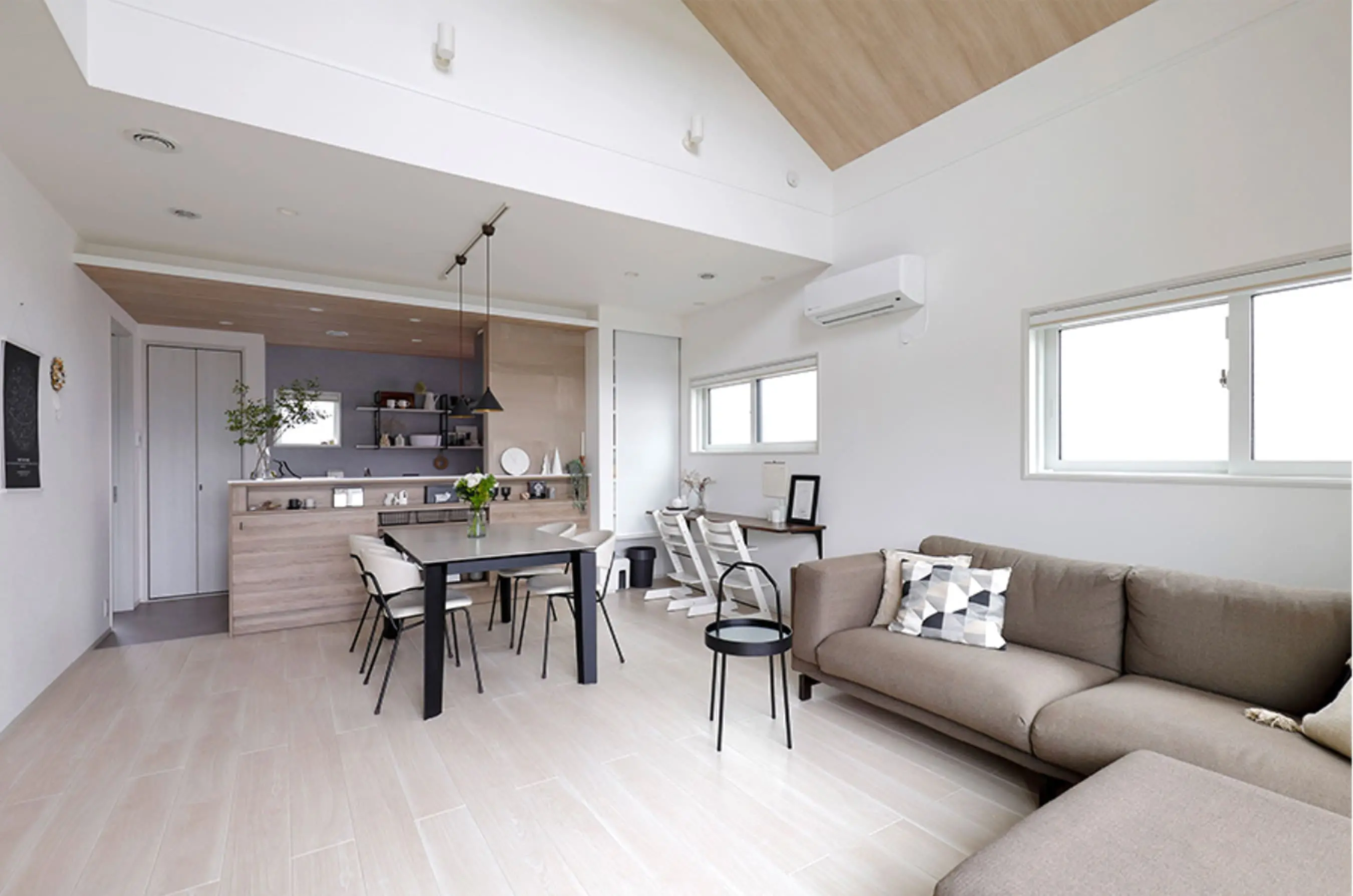 木目と白を基調にしたリビングダイニングで、ナチュラルな家具が配置された開放的な空間