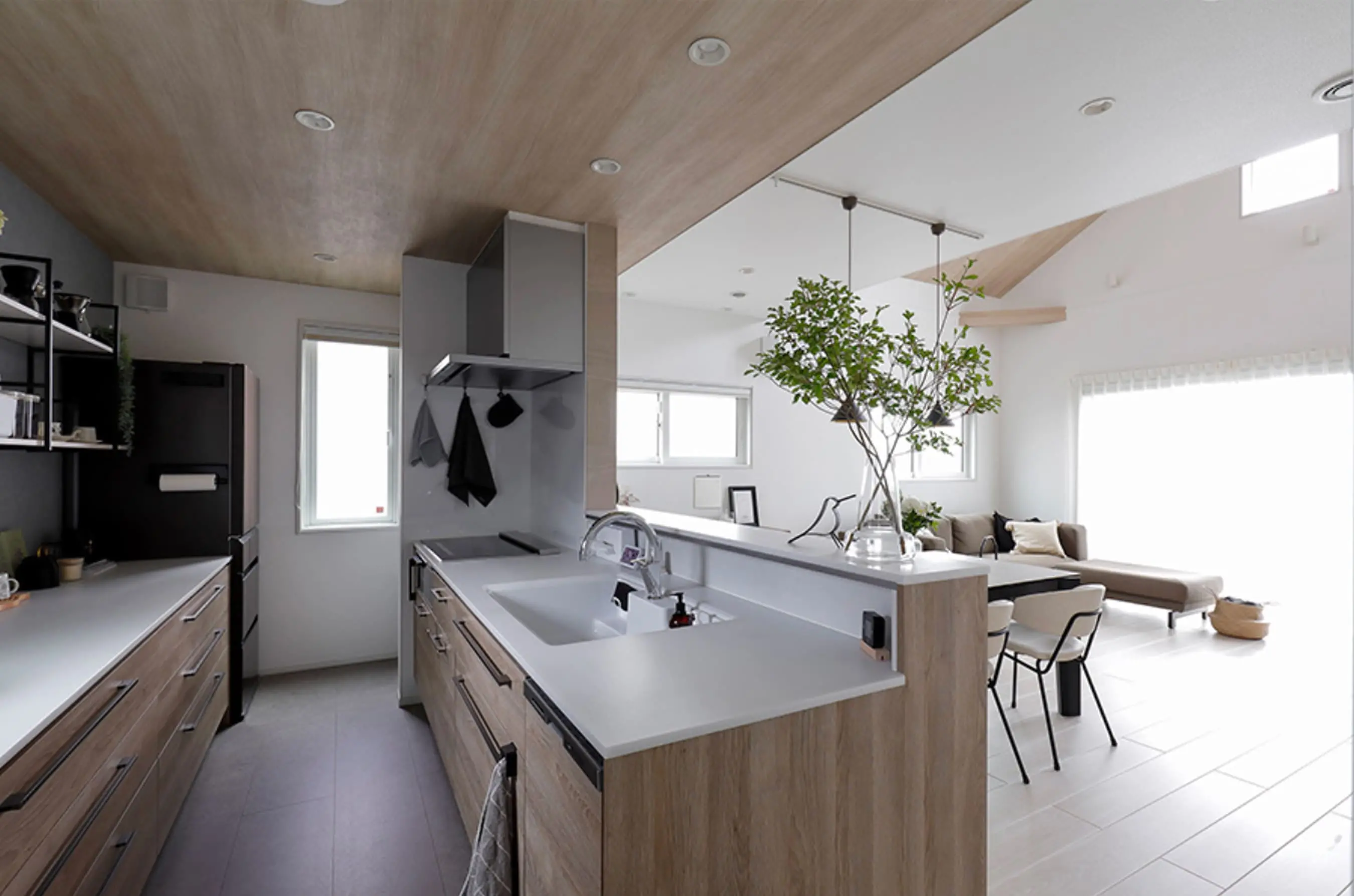 木目調の天井と収納が美しいキッチンで、リビングとつながる開放感あるレイアウト